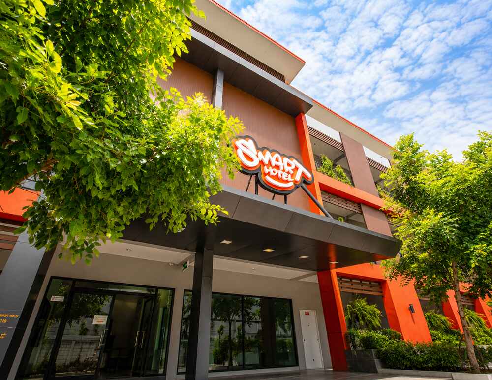 กันสาดทางเข้าและป้ายชื่อ Smart Hotel มองจากทางเข้ารถ